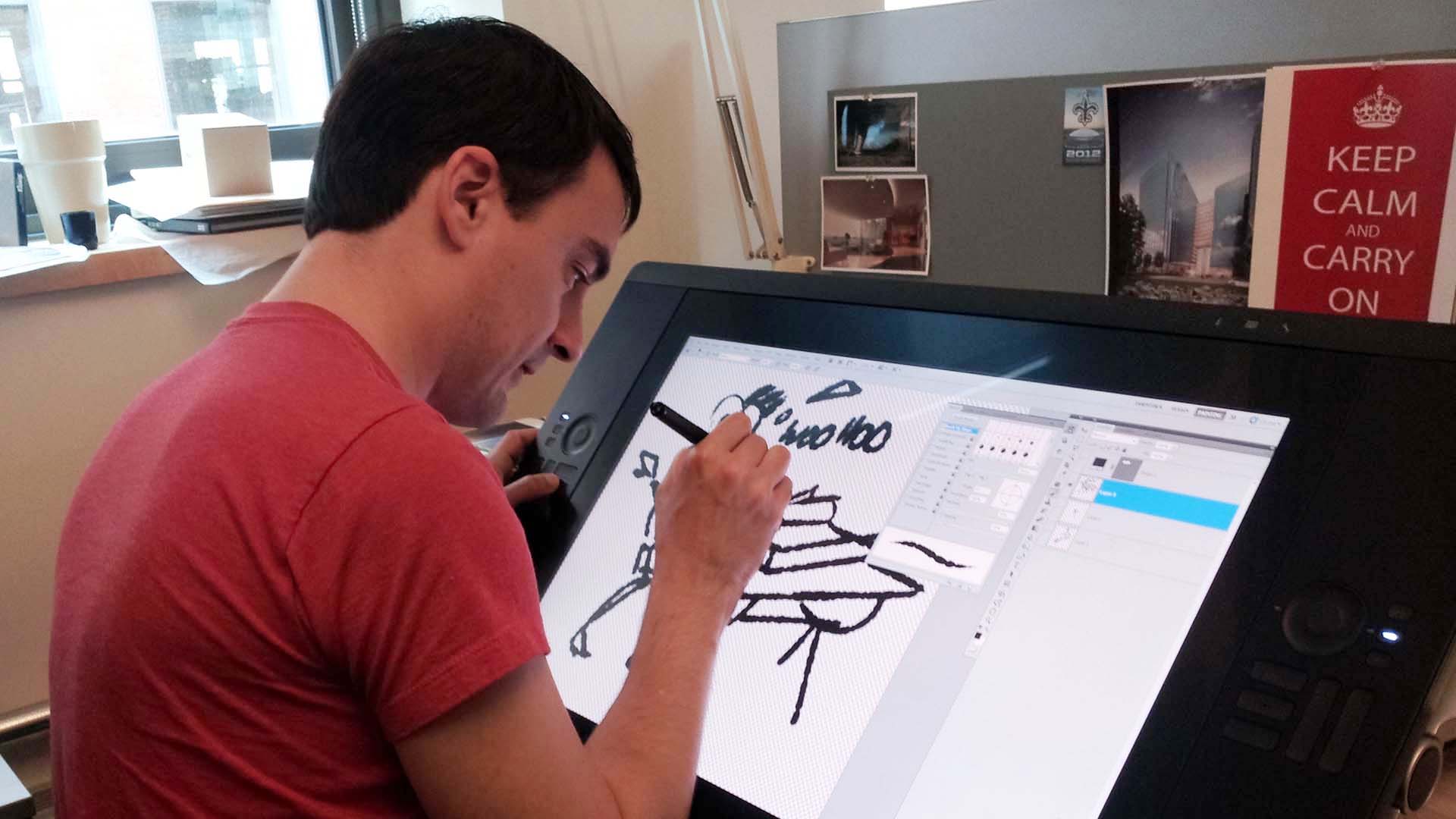 isral Duke working in front of a Wacom Cintiq, sketching ideations of a desk concept.